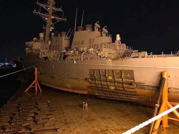 Погрузка поврежденного в столкновении американского эсминца USS John S. McCain (DDG 56) на платформу тяжелой баржи   MV Treasure, которая доставит его в ВМБ Yokosuka, Япония, для последующего ремонта, фото сделано 7 октября 2017 года в море, недалеко от побережья Сингапура