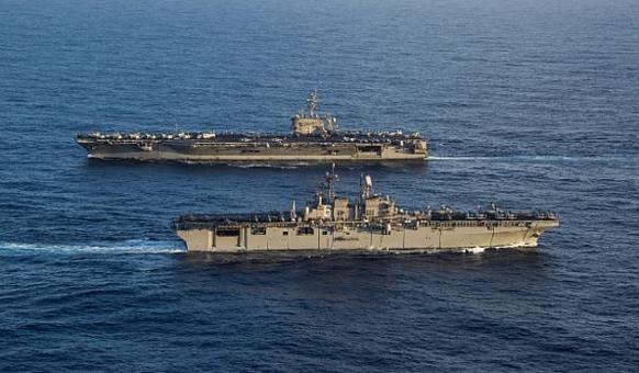 Встреча в океане:  универсальный десантный корабль (вертолетоносец) USS America (LHA 6), одноименного типа,  на переднем плане, и атомный авианосец USS Carl Vinson (CVN 70), типа Nimitz, фото сделано 20 января 2018 года в Тихом океане