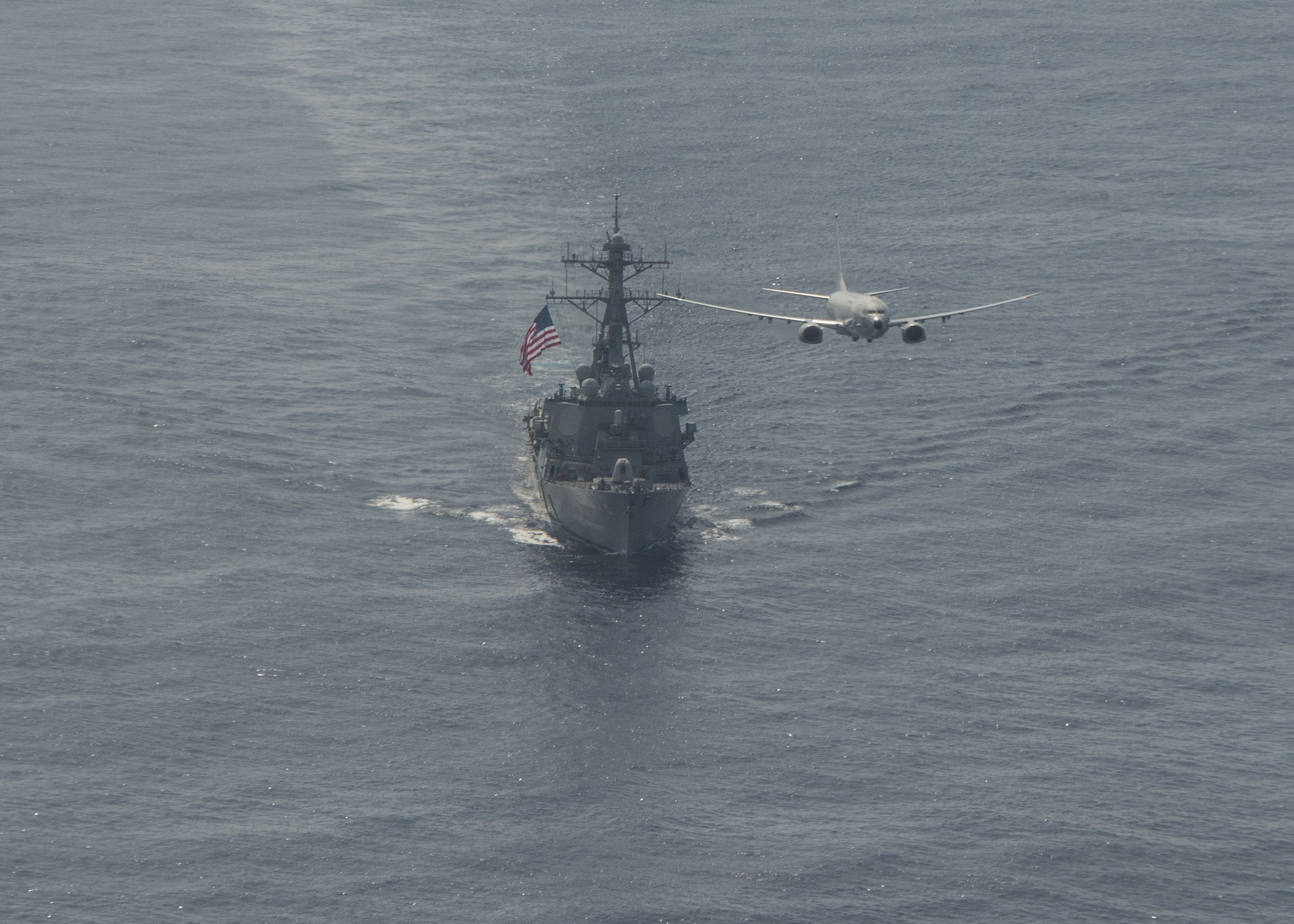 Многофункциональный морской патрульный самолет  P-8A Poseidon  4-й патрульной эскадрильи ВМС США и американский эсминец USS Porter (DDG 78), типа Arleigh Burke, на учении в Атлантике, фото сделано 29 марта 2020 года в зоне ответственности 6-го флота США