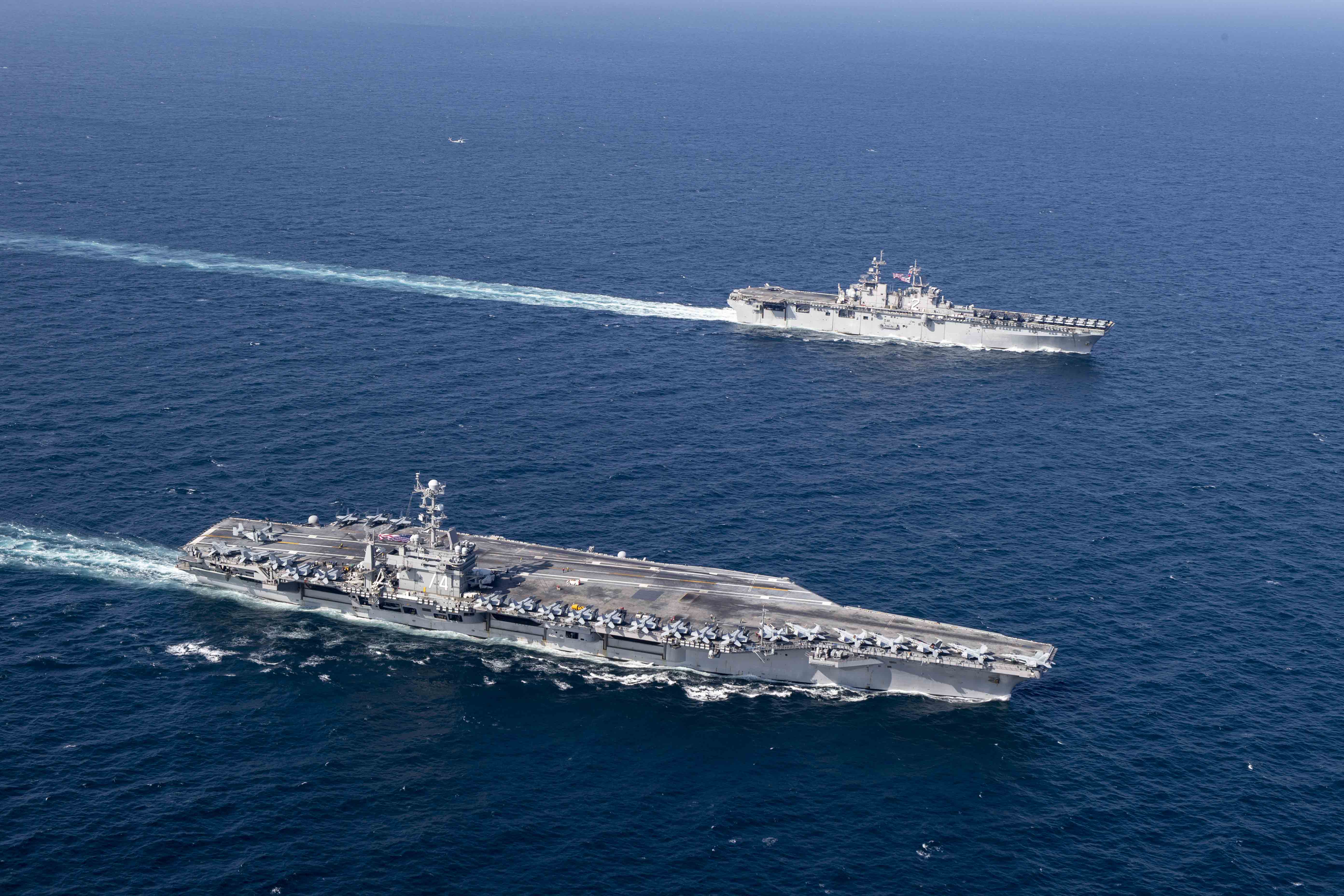 Авианосец USS John C. Stennis (CVN 74) и универсальный десантный корабль USS Essex (LHD 2) интегрировались в Персидском заливе для проведения совместных операций, фото сделано 14 декабря 2018 года